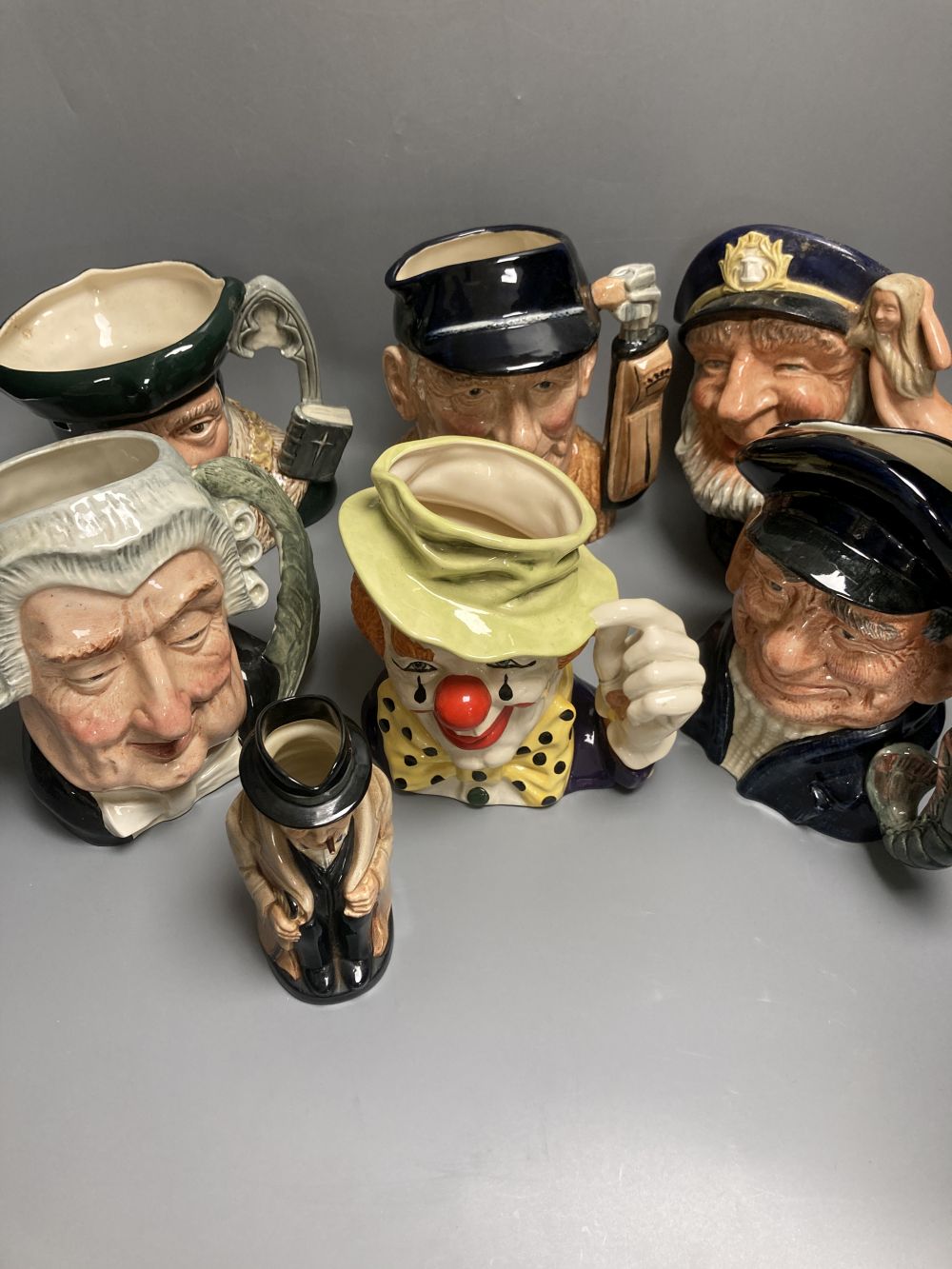Five Royal Doulton character jugs, a Royal Doulton The Clown character jug and a smaller Winston Churchill character jug